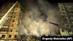 Рятувальники розчищають завали після влучання російської ракети в багатоповерховий будинок. Дніпро, 14 січня 2023 року