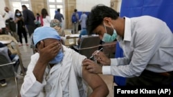 په کراچۍ کې روغتیاپال یو سړي ته د سینوفارم واکسین ستن لګوي - د ۲۰۲۱ز د مارچ ۱۰مې انځور