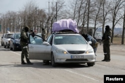 Військові РФ перевіряють автомобілі жителів Маріуполя, які виїжджають колоною з міста, 20 березня 2022 року