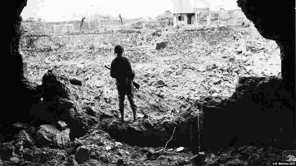 Морские пехотинцы США, которые осматривают последствия американской бомбардировки японского города Наха в префектуре Окинава в июне 1945 года, и украинский военнослужащий, который пробирается через обломки в торговом центре в Киеве после российского ракетного обстрела