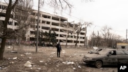 Фотограф Associated Press Євген Малолєтка стоїть на місці авіаудару по Приазовському державному технічному університету, 10 березня 2022 року, Маріуполь