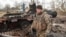 Украинский военнослужащий возле уничтоженного российского танка Т-72 в освобожденном селе Лукьяновка Киевской области, 27 марта 2022 года