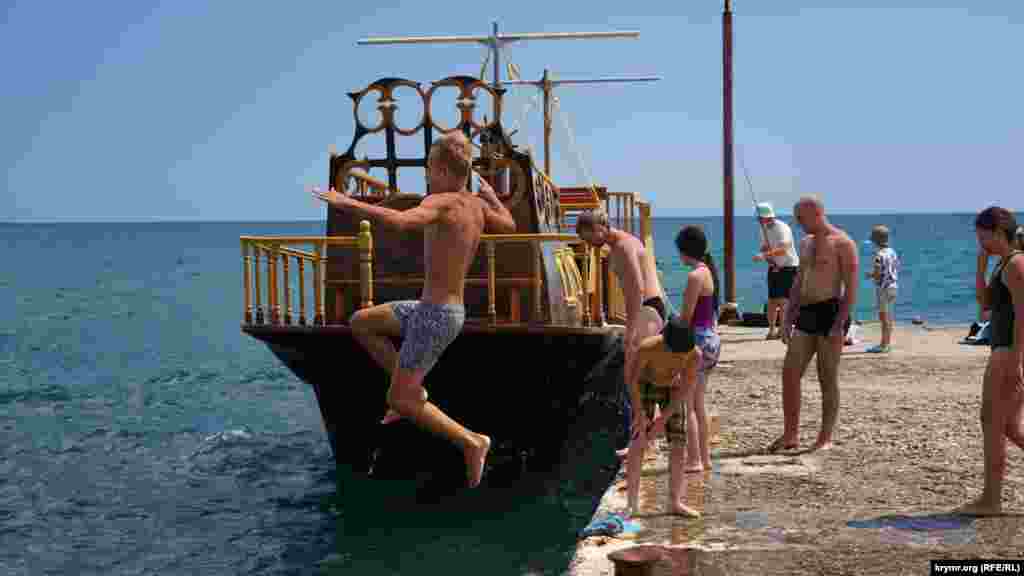 Июнь 2020 года. Крымчанин прыгает с пирса в восточной части поселка Новый Свет, у подножия горы Сокол. Прыгать с пирса или буны в Крыму – запрещено, однако некоторые отдыхающие игнорируют запреты