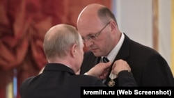 Президент России Владимир Путин награждает севастопольского депутата, предпринимателя Сергея Лисейцева российским орденом «Родительская слава», 30 мая 2019 года