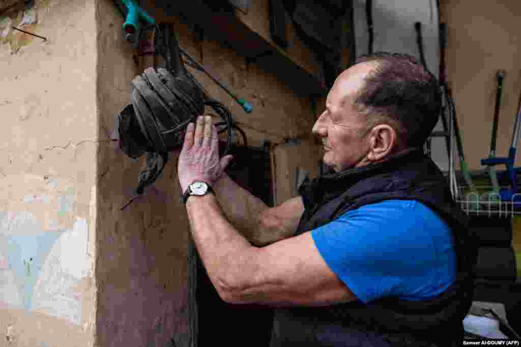 Андрій Плешан показує шолом російського танкіста. Подібних «подарунків» залишених російськими військовими у місті чимало. Люди жили в страху перед російськими військовими, які регулярно приходили обшукувати тих, хто ховався в підвалах. «Нас могли вбити будь-коли», – згадує Андрій Плешан, – «Це страждання об’єднало нас»