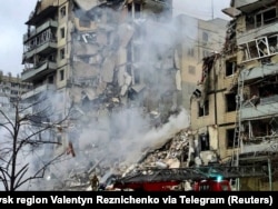 Рятувальники розчищають завали після влучання російської ракети в багатоповерховий будинок