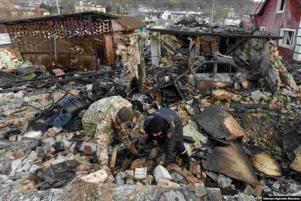 Слідчі працюють на місці пошкодження житлового будинку, як повідомили правоохоронці, під час російського удару безпілотниками у селі Старі Безрадичі Київської області, 19 грудня 2022 року