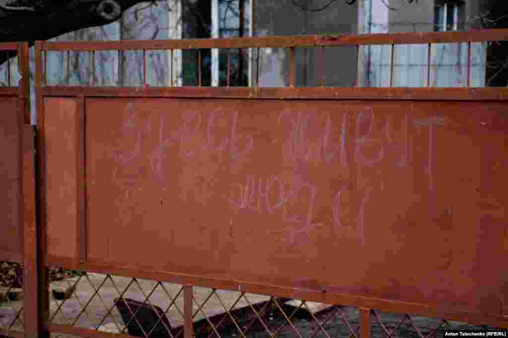Надпись на воротах на русском языке «Здесь живут люди». Таким образом жители показывали российским военным, что дом не пуст