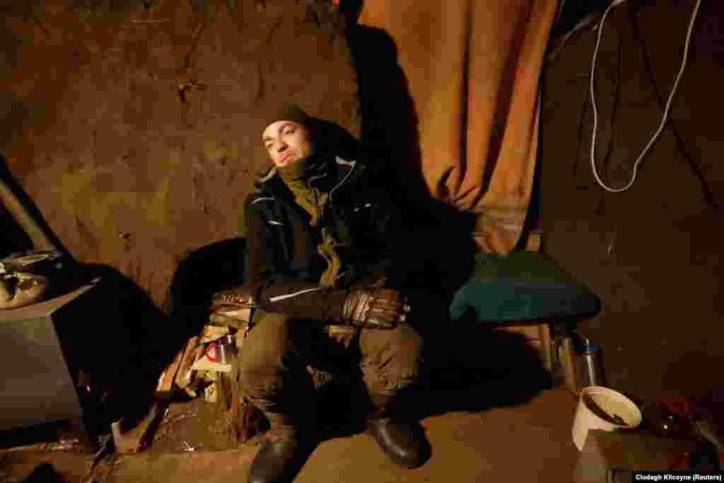 Военнослужащий 43-й отдельной артиллерийской бригады Виталий «Красавчик», 37 лет, ждет, пока закипит кастрюля с водой на позициях недалеко от Соледара, 11 января 2022 года.