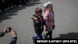 Діти біля школи №1 у Волновасі, квітень 2022 року. Місто підконтрольне російським військам та угрупованню «ДНР». За заявами окупаційної адміністрації, житловий фонд міста зруйнований на 85%