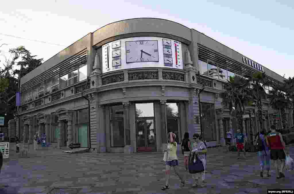 Когда-то это  был крутейший гастроном. Сейчас висит объявление об аренде. Место это считалось одним из самых  оживленных еще в Российской империи, затем в СССР,  ну и в Украине тоже – угол Аутской (затем Кирова, сейчас – Краснова) и Набережной. А на часах над входом по-прежнему  время мировых столиц. Только Москвы почему-то там нет