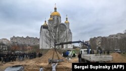 Ексгумація тіл загиблих із братської могили на території церкви в Бучі, 13 квітня 2022 року