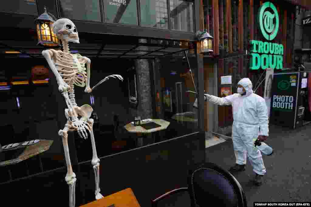 Сеул, Південна Корея: щоб запобігти поширенню COVID-19, чоловік розпилює дезінфікуючий засіб 