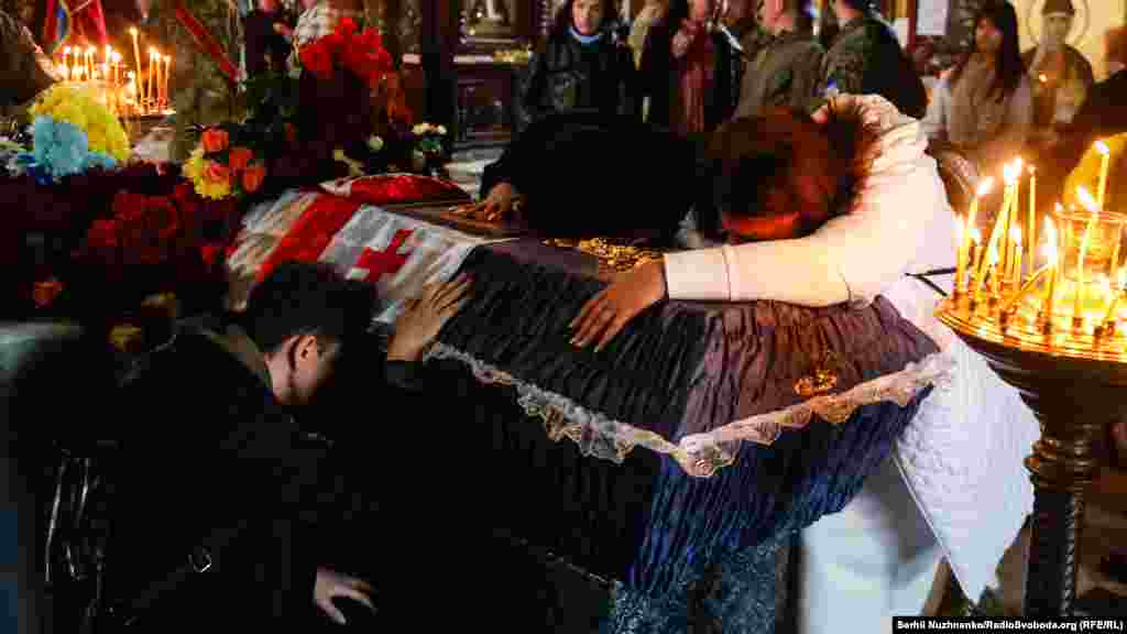 Рідні та близькі грузинського добровольця Едішера Кварцхелія під час церемонії прощання у Володимирському соборі. Київ, Україна