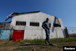 Охоронець стоїть перед будівлею в'язниці, де в липні 2022 року через теракт загинули українські військовополонені