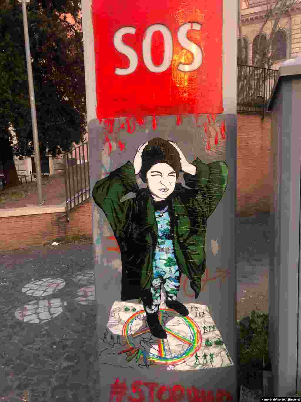 Малюнок SOS художника Гаррі Греба, нещодавно створений у Римі. Греб сказав Радіо Свобода, що кожен має зробити так, щоб його голос був почутий, і що зброя ніколи не повинна використовуватись для вирішення проблем. «Я не знаю, чи може моє мистецтво щось змінити, точно не самотужки», – сказав він. «Але разом, можливо, ми зможемо»