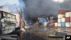 Containers burn on April 27 at the site of a massive explosion and fire that rocked a port near the southern port city of Bandar Abbas, Iran.