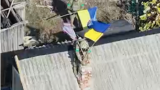 Боец Сил обороны устанавливает флаг над Сухецким на Добропольском выступе, октябрь 2025 года