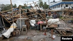 Чоловік рятує свої речі з-під завалів пошкодженого циклоном магазину в районі Парганас, Індія, 21 травня 2020 року
