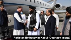 Pakistani Foreign Minister Shah Mahmood Qureshi (left) is welcomed upon arriving in Kabul on October 21.