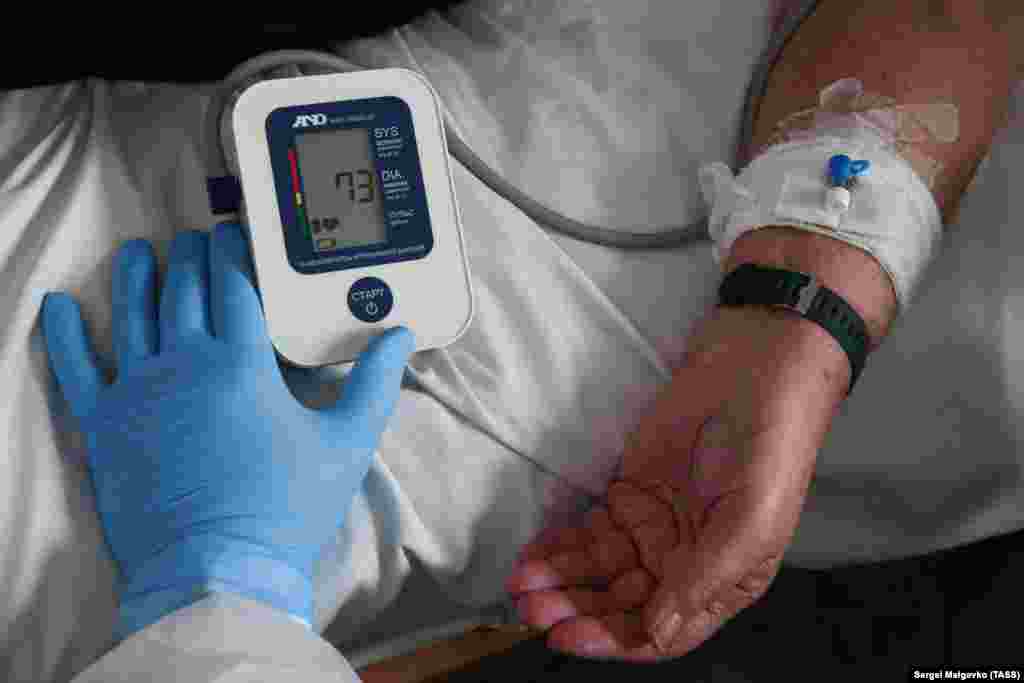 Медицинский сотрудник измеряет давление пациента в палате санатория «Прибой»