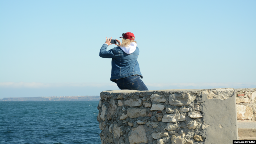 Молодая женщина снимает видео на мобильный телефон 