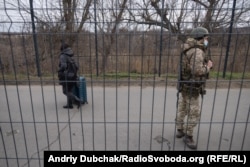 Жінка з валізою рухається в бік підконтрольної Україні території