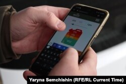 Микола Малуха на заправці у Києві демонструє додаток-калькулятор реальної вартості палива