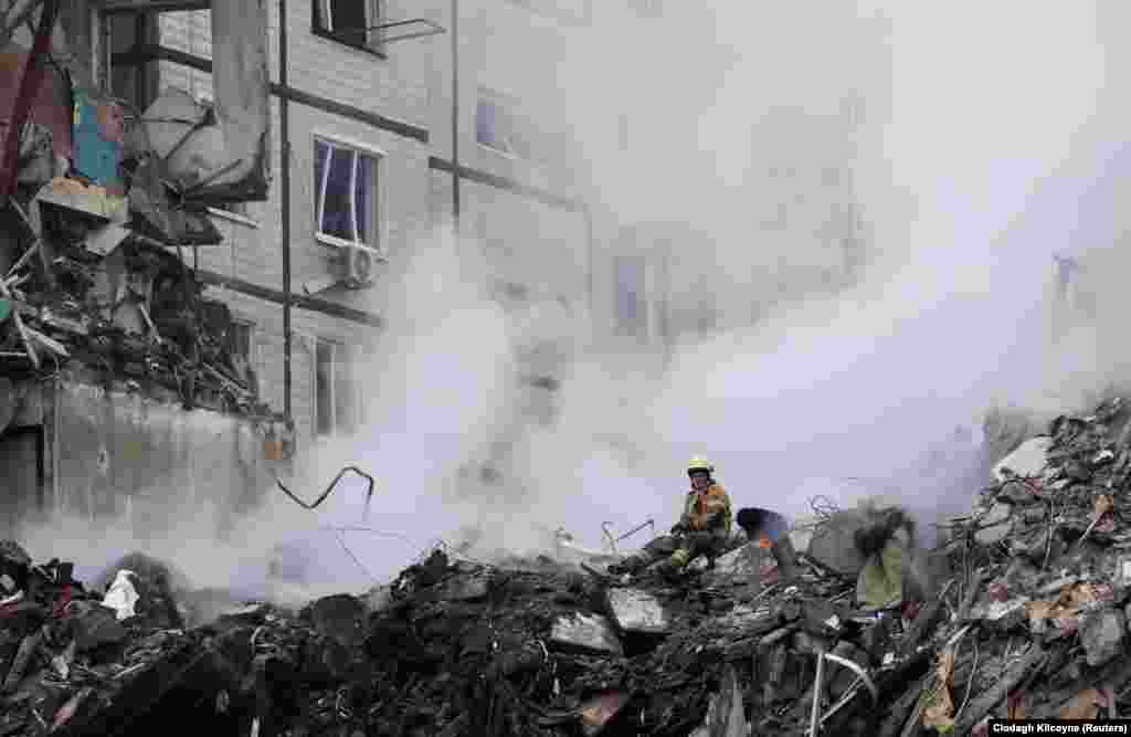 На місці, де російська ракета 14 січня влучила в житловий будинок у Дніпрі, тривають рятувальні роботи. Дніпро, 15 січня 2023 року