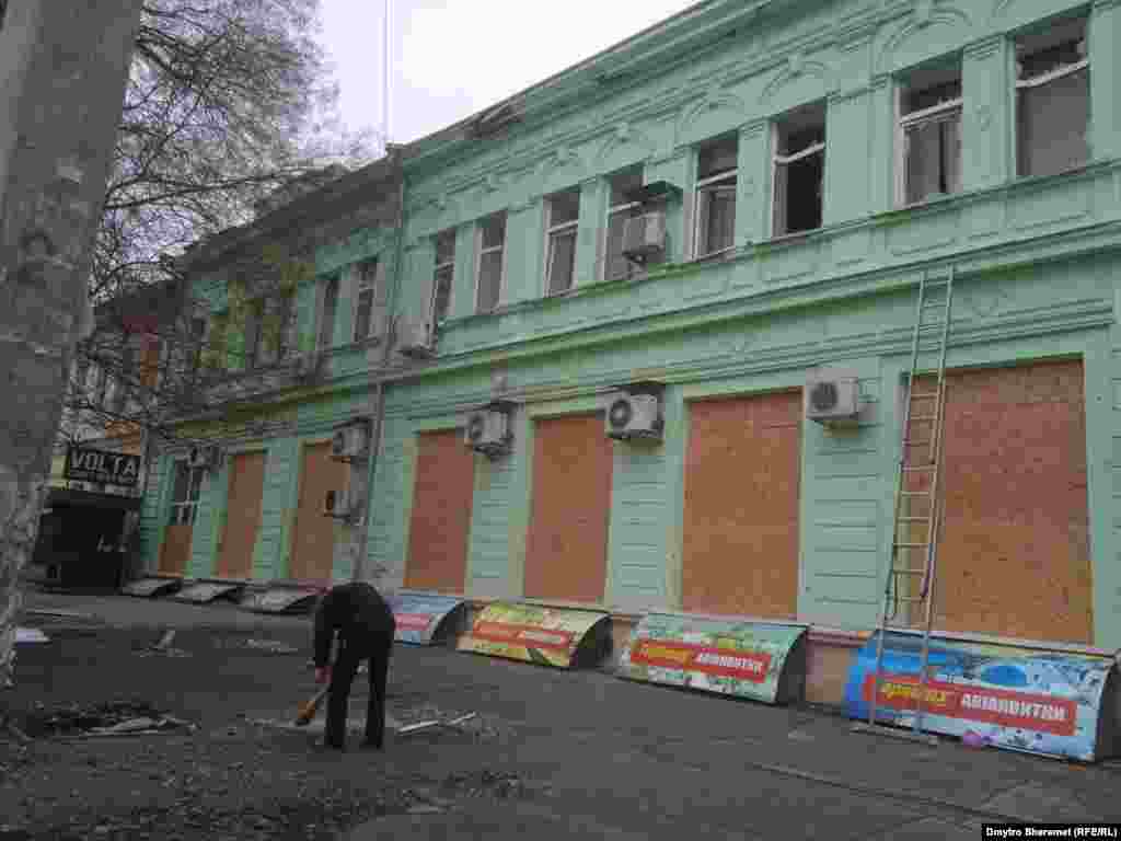 Вибиті вікна будівлі закривають фанерою