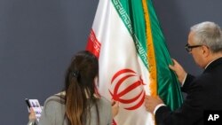 Članovi protokolarnog osoblja nameštaju iransku zastavu pre konferencije za novinare iranskog ministra spoljnih poslova Hoseina Amirabdolahijana sa njegovim srpskim kolegom Ivicom Dačićem u Beogradu, Srbija, 4. decembra 2022. godine.