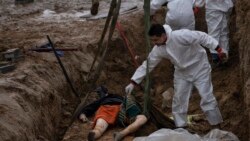 Una din victimele execuțiilor rusești ridicată cu o macara dintr-o groapă comună pentru identificare - Bucea, 10 aprilie 2022 - AP Photo/Rodrigo Abd