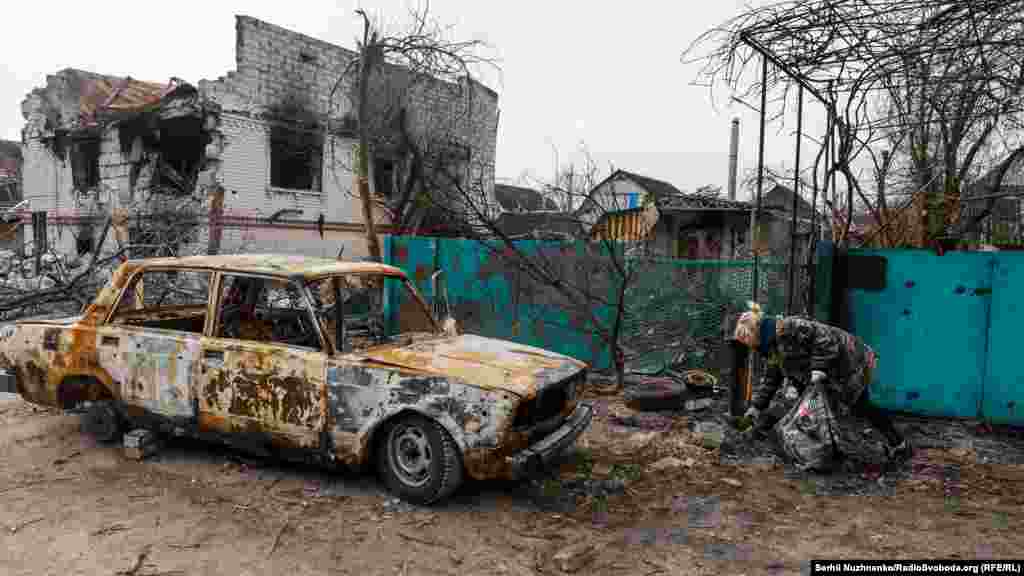 Місцева мешканка Людмила намагається хоч трохи прибрати біля свого будинку, якому пощастило вціліти. 6 квітня 2022 року