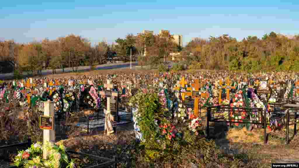 Новый заполненный могилами участок у старого городского кладбища «Абдал» на фоне строящегося микрорайона Крымская роза. Первые захоронения там состоялись прошлой весной. Ныне, по некоторым данным, в крымской столице ежедневно хоронят пять-шесть умерших от короновируса. Такие жилые кварталы с видом на кладбище горожане называют «живые и мертвые»