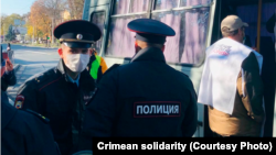 Российские силовики задерживают людей, пришедших протестовать под здание суда, выносящего приговоры в отношении крымских мусульман. Симферополь, 21 октября 2021 года