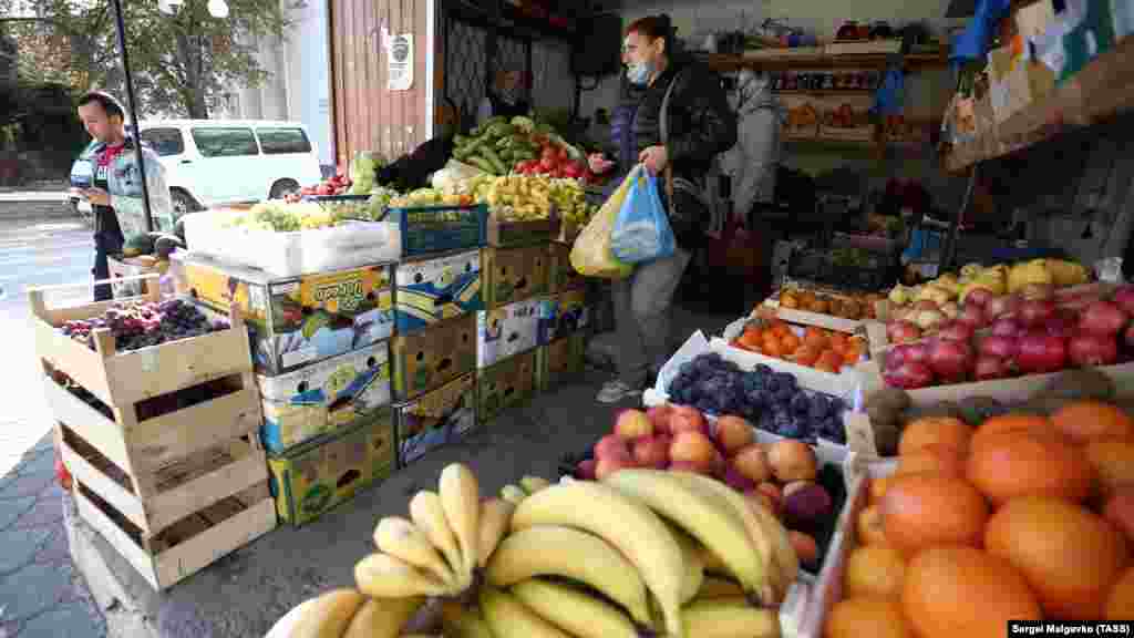 Люди в ларьке с фруктами и овощами носят маски неправильно – опустив их на подбородок