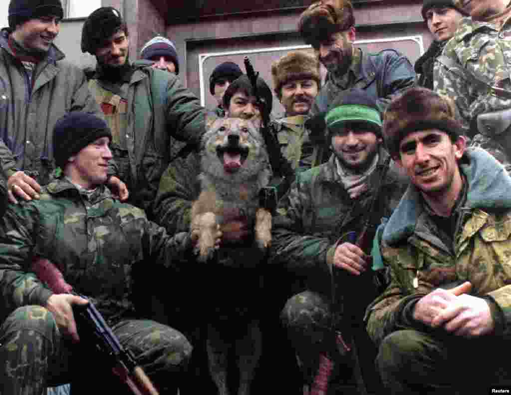 Чеченские ополченцы с волком позируют для фотографии у главного входа в президентский дворец в Грозном, 18 декабря 1994 года. Волк для чеченского народа – символ свободы и независимости