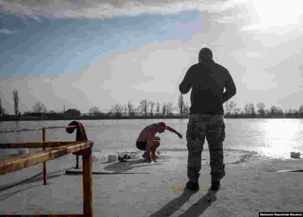 Українські військовослужбовці готуються пірнути в крижану воду на Водохреща (свято Хрещення Господнього) за юліанським календарем у час війни Росії проти України.  Слов'янськ, Донецька область, Україна. 19 січня 2023 року