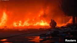 Рятувальники працюють на місці влучання російського безпілотника у приватне підприємство на околиці Сум, 15 травня 2025 року