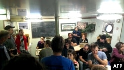 Члени екіпажу Greenpeace на борту свого корабля під час буксирування його береговою охороною в Мурманськ, 24 вересня 2013 року