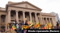 Протестувальники святкують після штурму резиденції президента Шрі-Ланки Готобаї Раджапакси, 9 липня 2022 року