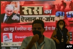 U Indiji su se s oažnjom pratile vesti koje su dolazile iz Ukrajine s početka ruske agresije, na fotografiji ljudi prolaze pored ekrana sa vestima u Mumbaiju, februar 2022.