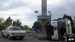 Прапори незаконного збройного угруповання «ДНР» та Чеченської республіки Росії на в’їзді до Маріуполя, 9 травня 2022 року