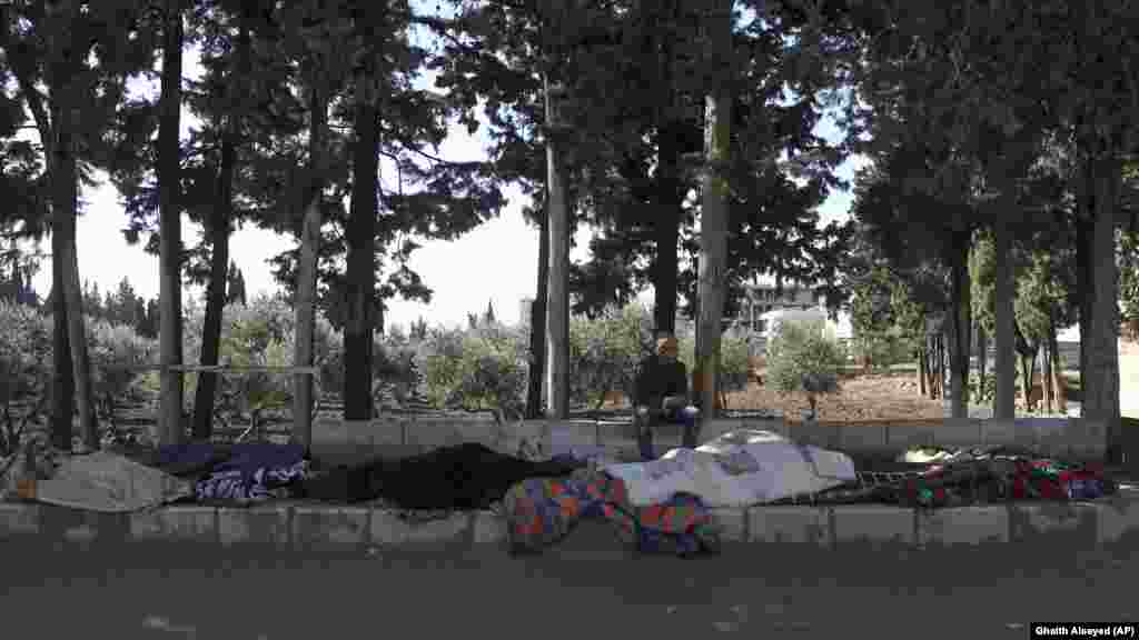 Мужчина сидит рядом с телами членов своей семьи, погибших в результате разрушительного землетрясения, которое потрясло Сирию и Турцию.  то город Джиндерис, провинция Алеппо, Сирия, вторник, 7 февраля 2023 года. емлетрясение разрушило тысячи зданий, тысячи людей погибли. Сирии и до этого была разрушена более чем десятилетним конфликтом и экономическим кризисом.  