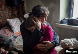 Бабуся Ольга обіймає свою 6-річну онуку Аріну, Бахмут