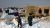Afghan internally displaced children shovel snow near their tents during a cold winter day in the Nahr-e Shah-e district of Balkh Province on January 17.