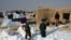 Afghan internally displaced children shovel snow near their tents during a cold winter day in the Nahr-e Shah-e district of Balkh Province on January 17.