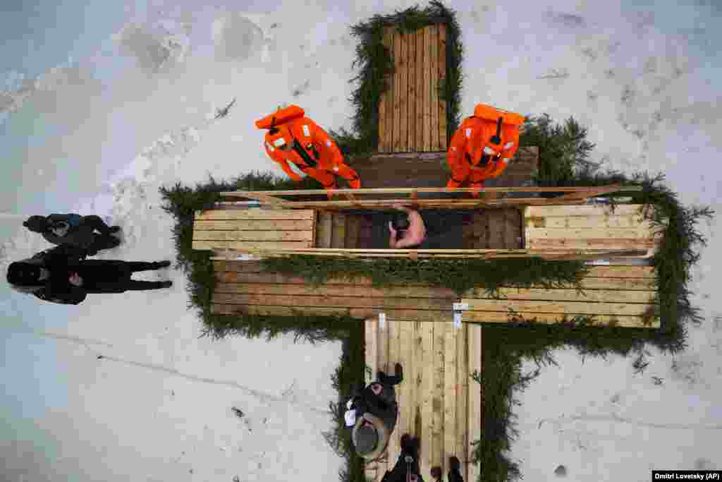 Thousands of Orthodox followers plunged into outdoor rivers, ponds, or other pools, such as these people under the watchful gaze of rescue workers in Kronstadt, outside St. Petersburg, Russia, on January 18.  