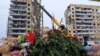 Люди приносять квіти та іграшки до місця ракетного удару по Дніпру. 17 січня 2023 року