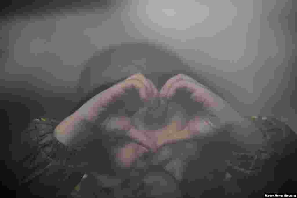 Un copil care a plecat din Ucraina formează simbolic o inimă pe geamul unui tren din gara Nyugati, Budapesta, 28 februarie 2022. REUTERS/Marton Monus   